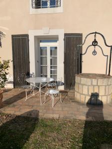 eine Terrasse mit einem Tisch und einem Brunnen in der Unterkunft CHAMBRE D'HOTE in Gignac