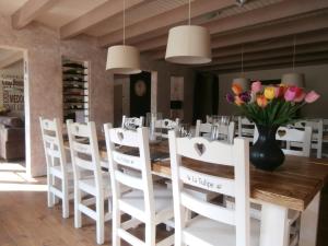 un comedor con mesa y sillas y un jarrón de flores en Chambres d'Hôtes La Tulipe, en Champdray