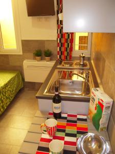una cocina con fregadero y una botella de vino en Bolognahome, en Bolonia