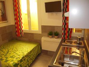 una cocina con fregadero y una cama en una habitación en Bolognahome, en Bolonia