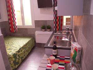 cocina pequeña con fregadero y cama en Bolognahome, en Bolonia