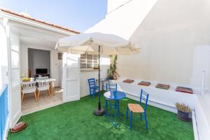 a patio with a table and chairs and an umbrella at Town Apartment with panoramic seaview in Paphos