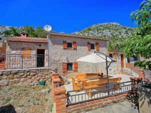 a stone house with an umbrella in front of it at Lovely Holiday Home in Starigrad with Private Swimming Pool in Starigrad-Paklenica