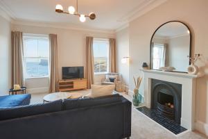 ein Wohnzimmer mit einem Sofa und einem Kamin in der Unterkunft Host & Stay - Huntcliff View Apartment in Saltburn-by-the-Sea