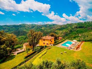 eine Luftansicht eines Hauses auf einem Hügel mit Pool in der Unterkunft Villa Armonia Toscana - Homelike Villas in Massa e Cozzile