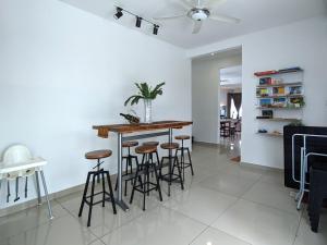 a kitchen and living room with a bar with stools at Lux Villa 6rm 12 to 22 pax Wifi Netflix BBQ SteamBoat Games Beach Water Park in Desaru