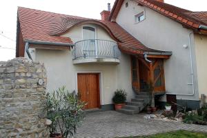 uma casa branca com uma varanda e um alpendre em Luca Vendégház em Sárvár