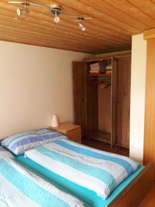 Schlafzimmer mit einem Bett mit Holzdecke in der Unterkunft Ferienwohnung Gafner in Brienz