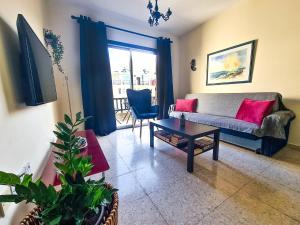 ein Wohnzimmer mit einem Sofa und einem Tisch in der Unterkunft Lisa's Apartment - Margarita Gardens in Paphos City