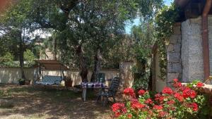 - une table et des chaises dans une cour fleurie dans l'établissement Pedras House Holidays, à Santa Maria Navarrese