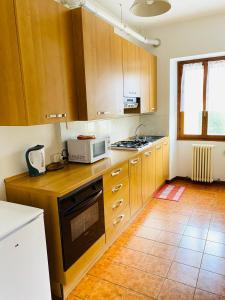 cocina con armarios de madera y microondas en Appartamento Rosso, en Lazise