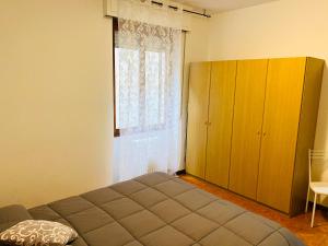 1 dormitorio con cama y ventana grande en Appartamento Rosso, en Lazise