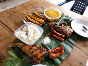 a plate of food with rice and meat on a banana leaf at Reserva Natural Tucuchira in Santa Sofía