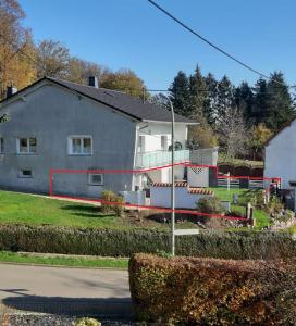 uma casa com uma fita à volta da frente. em Ferienwohnung Zur Waldkapelle em Nohfelden