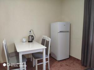 uma pequena cozinha com uma mesa e um frigorífico em Apartments Domovik "Elegance" em Mukachevo