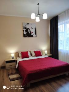 a bedroom with a large bed with a red blanket at Apartments Domovik "Elegance" in Mukacheve