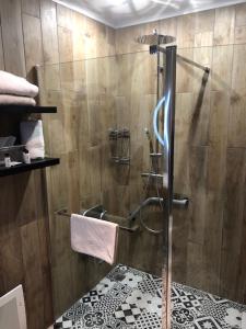 a shower with a glass door in a bathroom at Les Jardins d'Ulysse, The Originals Relais (Relais du Silence) in Stella-Plage