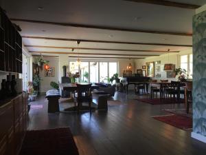 a living room with tables and chairs and a living room at Hørhaven B&B in Fuglebjerg