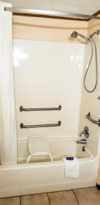uma casa de banho com banheira e cortina de chuveiro em Knights Inn Greenville em Greenville
