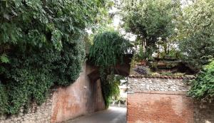 een steegje met een stenen muur en een poort bij Vicolo Del Nido B&B in Paderno Franciacorta