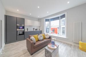 ブライトン＆ホーブにあるSpecial Offer Brighton City Centre Seafront 1 Bedroom Flat BN133DUK01のソファとキッチンのあるリビングルーム