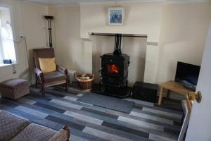 a living room with a wood stove in a room at Meenadreen Cottage in Donegal