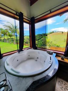 布埃諾布蘭的住宿－Chalés e Bangalôs Capim Limão，带大窗户的客房内设有一个大浴缸