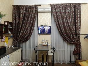 a kitchen with a table and a window with curtains at Gorsad Apartment in Odesa +12 photos