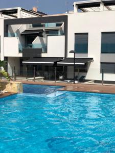 a swimming pool in front of a building at OASIS BEACH 7 - Apartment Lundgren in Torrevieja