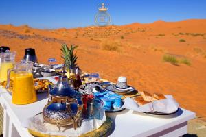 a table in the desert with food on it at ITRAN ROYAL CAMP in Merzouga