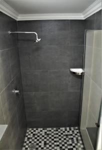 Łazienka z prysznicem i podłogą wyłożoną kafelkami w obiekcie Mahem Manor Guesthouse w mieście Brits