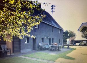 a house with a table and chairs in front of it at FEWO Wittener Hütte in Langenbach b.K. in Langenbach bei Kirburg