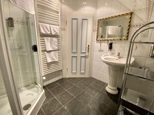 a white bathroom with a sink and a shower at Hotel Residenz Rennhack in Prerow