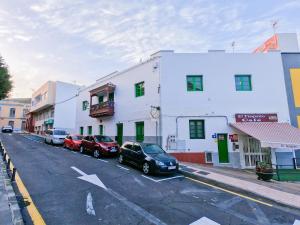 a street with cars parked in front of buildings at Casa Blanca Guest House Tenerife in Granadilla de Abona