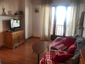 a living room with a couch and a television at Studio Valberg à quelques pas du centre in Péone
