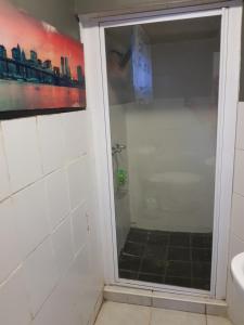 ein Bad mit einer Dusche und einer Glastür in der Unterkunft The Budget Inn in Bloemfontein