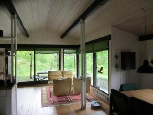 a living room with chairs and sliding glass doors at Holiday Home Holmehøj in Ebeltoft