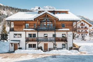 una casa nella neve con balcone di Garnì Iosc a San Vigilio Di Marebbe