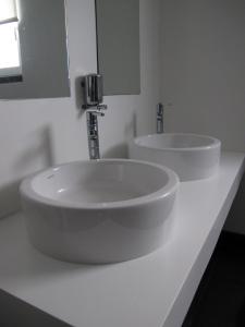 Baño blanco con 2 lavabos y espejo en Azores Youth Hostels - Santa Maria, en Vila do Porto