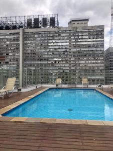 a large building with a large blue swimming pool at Flat Jardins - Paulista in Sao Paulo