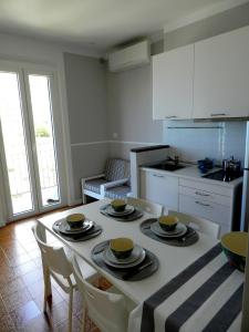 una cocina con una mesa con platos y tazas. en ARIA DI MARE, Manarola - Appartamento THE VIEW, en Manarola