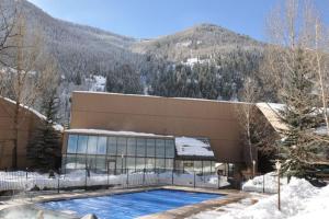 a building with a swimming pool in the snow at Pitkin Creek Park 7 in Vail