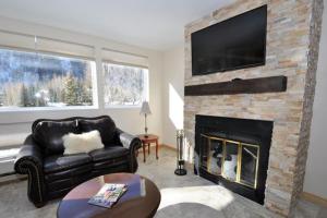 a living room with a fireplace with a flat screen tv at Pitkin Creek Park 7 in Vail