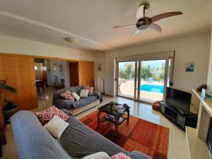a living room with a couch and a ceiling fan at Argo Villa Kalives in Kalyves
