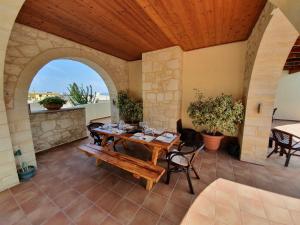 an outdoor patio with a wooden table and chairs at Argo Villa Kalives in Kalyves