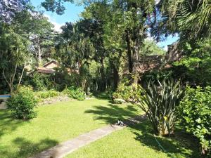 un jardín con árboles, césped y acera en Rosalia Suites en Loma Hermosa