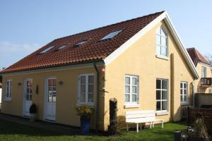 a yellow house with a bench in front of it at Holiday-Skagen in Skagen