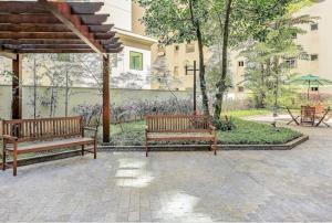 two benches sitting under a pavilion in a park at Flat Jardins - Paulista in Sao Paulo