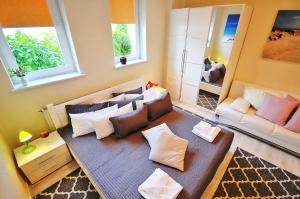 salon z kanapą i dwoma oknami w obiekcie Plaża Apartament w mieście Ustronie Morskie