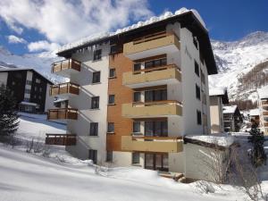 a apartment building in the snow with snow at Adular in Saas-Fee
